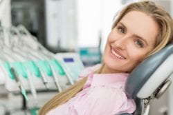 woman smiles in dentist chair after getting tmj treatment